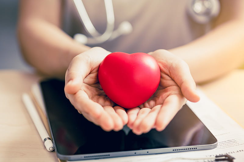 Close up of hands holding a heart-shaped stress relief ball