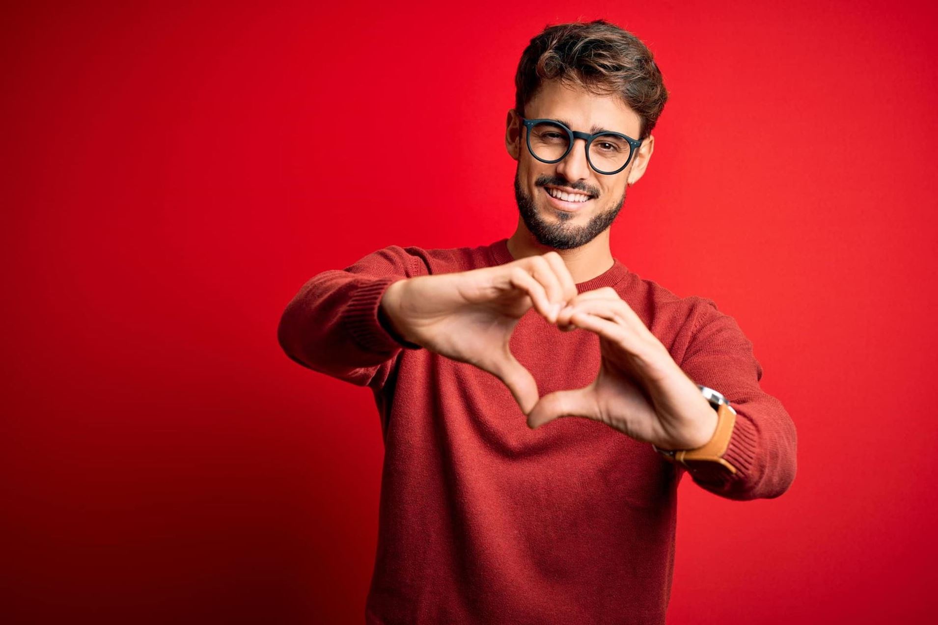 a white male in his 30s holding his hands out in a heart shape