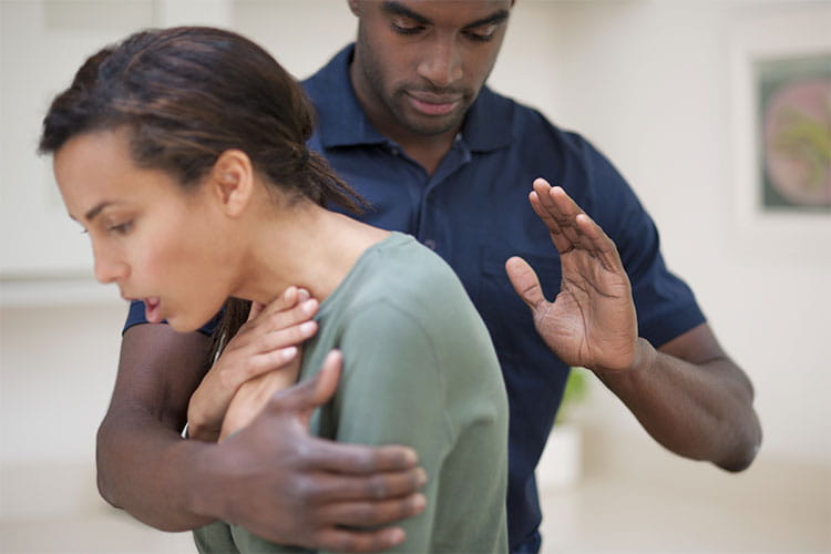 man assisting woman who is choking